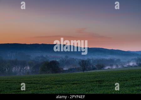 Farbenfroher Sonnenaufgang an einem Sommermorgen mit einem kleinen Nebel auf dem Boden und spektakulärer Aussicht auf die holländischen Hügel in der Nähe des Dorfes Kuttingen Stockfoto