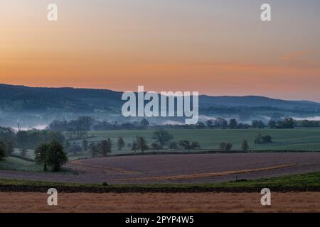 Farbenfroher Sonnenaufgang an einem Sommermorgen mit einem kleinen Nebel auf dem Boden und spektakulärer Aussicht auf die holländischen Hügel in der Nähe des Dorfes Kuttingen Stockfoto
