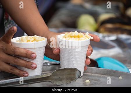 Authentische Mexikanische Esquites (Mexikanischer Maissalat). eine dame, die Esquites in einem Straßenstand verkauft Stockfoto