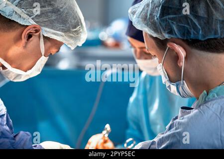 Gesichter von Chirurgen im Operationssaal während der Operation, moderne Medizin, medizinisches Personal während einer komplexen Operation, medizinische Wissenschaft, Nahaufnahme. Stockfoto