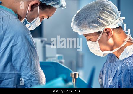 Gesichter von Chirurgen im Operationssaal während der Operation, moderne Medizin, medizinisches Personal während einer komplexen Operation, medizinische Wissenschaft, Nahaufnahme. Stockfoto