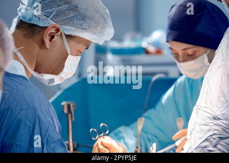 Gesichter von Chirurgen im Operationssaal während der Operation, moderne Medizin, medizinisches Personal während einer komplexen Operation, medizinische Wissenschaft, Nahaufnahme. Stockfoto