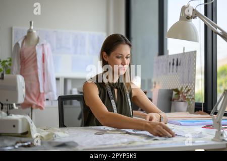Eine schöne Schneiderin, die im Werkstatt-Studio arbeitet Stockfoto