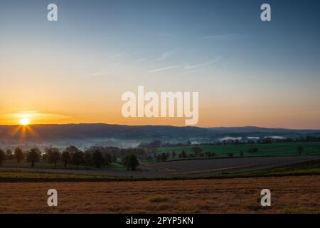 Farbenfroher Sonnenaufgang an einem Sommermorgen mit einem kleinen Nebel auf dem Boden und spektakulärer Aussicht auf die holländischen Hügel in der Nähe des Dorfes Kuttingen Stockfoto
