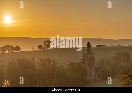 Farbenfroher Sonnenaufgang an einem Sommermorgen mit einem kleinen Nebel auf dem Boden und spektakulärer Aussicht auf die holländischen Hügel und eine malerische Burg Stockfoto