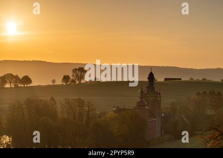 Farbenfroher Sonnenaufgang an einem Sommermorgen mit einem kleinen Nebel auf dem Boden und spektakulärer Aussicht auf die holländischen Hügel und eine malerische Burg Stockfoto
