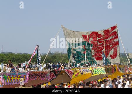 Sagamihara, Japan, Mai 5. 2023, Ein großer Drachen über den Speise- und Unterhaltungsständen beim Sagami Giant Kite Festival (Sagami-no-Oodako) Sagamihara. Das Sagami Giant Kite Festival begann in den 1830er Jahren als Ergänzung zum Children's Festival, das am 5. Mai in japan gefeiert wird. Mit der Zeit sind die Drachen, die aus Bambus und handgemachtem Papier bestehen, größer geworden. Die größten Drachen, die während dieses Festivals vom Flussufer der Sagami geflogen wurden, sind etwa 15 Meter lang und können über 900 Kilogramm wiegen. Ein Team von 80 bis 100 Personen braucht sie, um sie in die Luft zu jagen. Stockfoto