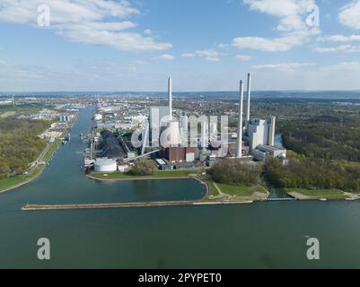 Ein faszinierender Blick aus der Vogelperspektive auf das beeindruckende Kraftwerk Karlsruhe vor dem Hintergrund des belebten Rheinhafens. Stockfoto