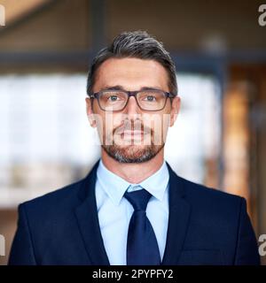 Geschäfte zum Nennwert annehmen. Porträt eines selbstbewussten Geschäftsmannes, der im Büro lächelt. Stockfoto