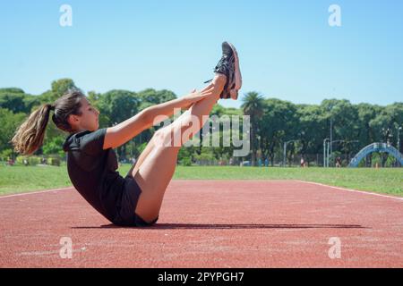 Junge lateinerin argentinischer ethnischer Herkunft, Bauchmuskeln trainieren, Beine vertreten und Füße mit Händen berühren, Kopierraum. Stockfoto