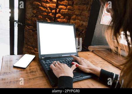 Junge transsexuelle argentinische Freiberuflerin Latina, die auf dem Laptop tippt und im Internet surft, während sie in ihrem Online-Geschäft arbeitet. Stockfoto