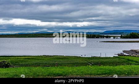 Ein Blick auf Lough Erne in Co Fermanagh, Nordirland, während ein kleines Boot die Wasserstraße durchquert Stockfoto