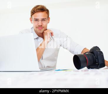 Hübscher Fotograf. Porträt eines gutaussehenden jungen Fotografen mit Laptop. Stockfoto