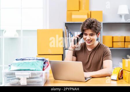 Start-up-Unternehmen Kleinunternehmer KMU, asiatischer Mann erhalten Bestellung am Telefon. Portrait junger asiatischer Kleinunternehmer, Heimbüro, Packkartons Stockfoto