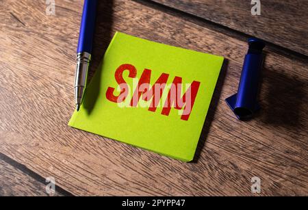 Auf Tastatur-Notebook Holzblöcke mit der Aufschrift - SMM - roter Hintergrund. Finanz- und Wirtschaftskonzept. Stockfoto