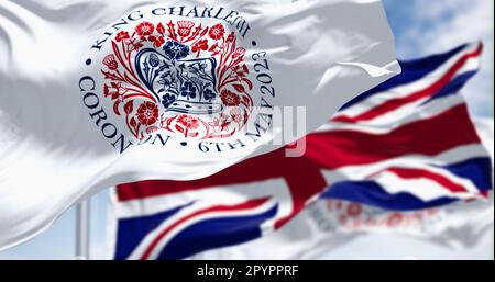 London, Vereinigtes Königreich, April 2023: Flaggen mit dem Emblem der Krönung von König Karl III. Und der Wunschflaggen des Vereinigten Königreichs. Redaktioneller 3D-Illustrations-Rendering. Stockfoto