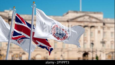 London, Vereinigtes Königreich, April 2023: Flaggen mit dem Emblem der Krönung von König Karl III. Und der Wunschflaggen des Vereinigten Königreichs. Redaktioneller 3D-Illustrations-Rendering. Stockfoto