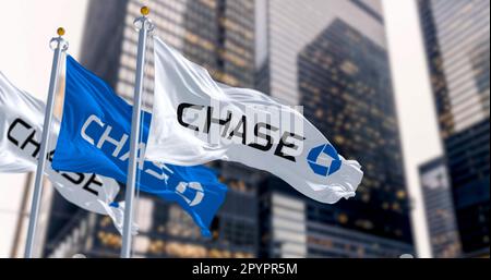 New York, USA, März 2023: Flags of Chase Bank winkend im Wind in einem Finanzviertel. Die JPMorgan Chase Bank ist eine amerikanische Nationalbank. Illustrati Stockfoto