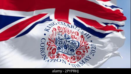 London, Vereinigtes Königreich, April 2023: Flaggen mit dem Emblem der Krönung von König Karl III. Und der Wunschflaggen des Vereinigten Königreichs. Redaktioneller 3D-Illustrations-Rendering. S Stockfoto