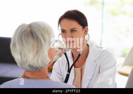 Sie konzentriert sich auf hochwertige Pflege. Porträt eines jungen Arztes, der einem älteren Patienten aufmerksam zuhört. Stockfoto