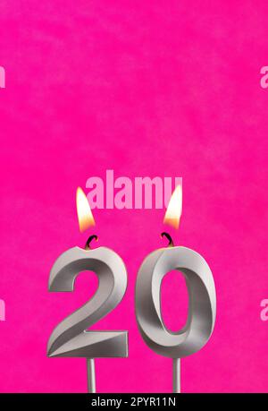 Kerze Nummer 20 - Geburtstagsfeier mit fuchsianischem Hintergrund Stockfoto