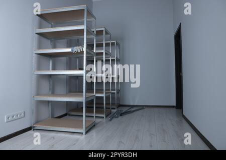 Büroraum mit weißen Wänden und Lagerregalen aus Metall Stockfoto