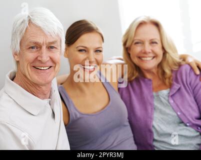 Sie sind meine Vorbilder. Eine wunderschöne junge Frau, die zwischen ihren älteren Eltern sitzt. Stockfoto