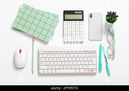 Komposition mit Taschenrechner, Mobiltelefon, Brille und Tastatur auf weißem Hintergrund Stockfoto