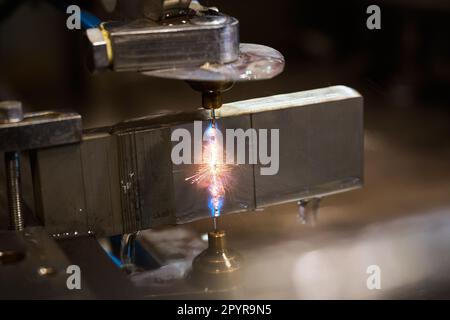 Die Gasschneidemaschine arbeitet mit einem Metallblock in der Werkstatt Stockfoto