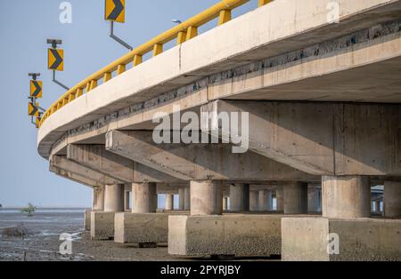 Struktur der Stahlbetonbrücke entlang des Meeres. Untersicht der Betonbrücke. Betonbrückenbau. Moderne Zementbrücke Stockfoto