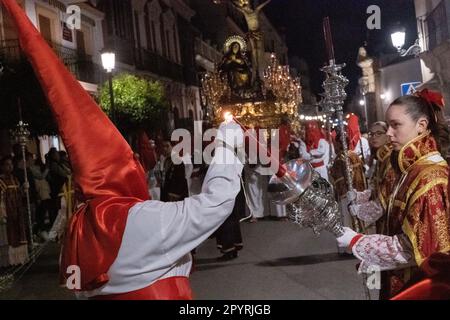 Cofradias, die rote konische Kapuzen tragen, zünden ihre Kerzen während der Mitternachtsstummen Prozession an, die Karfreitag in der Heiligen Woche oder Semana Santa, 6. April 2023 in Ronda, Spanien, feiert. Ronda, die sich im 6. Jahrhundert v. Chr. niedergelassen hat, hält seit über 500 Jahren Heilige Woche-Prozessionen ab. Stockfoto