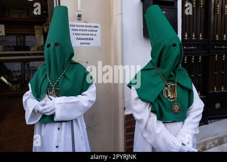 Cofradias mit grünen Kapuzen stellen sich während der Heiligen Woche vor einer Prozession auf oder Semana Santa, 5. April 2023 in Ronda, Spanien. Ronda, die sich im 6. Jahrhundert v. Chr. niedergelassen hat, hält seit über 500 Jahren Heilige Woche-Prozessionen ab. Stockfoto