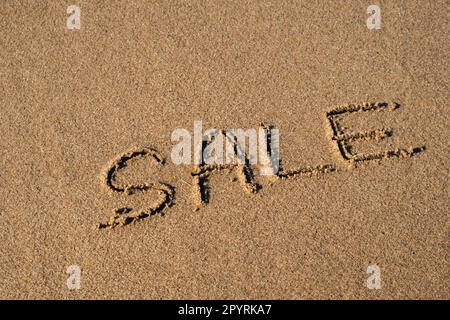 Handgeschriebener TEXTVERKAUF auf Sandoberfläche. Werbekonzept Black Friday Blue Ocean Wave wäscht Nachricht am Strand ab. Sommerferien Strandurlaubskonzept Stockfoto