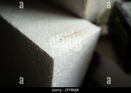 Weißes dickes Styropor-Nahbild. Universelles Isoliermaterial aus geschäumtem Polystyrol. Stockfoto