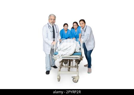Ein Team von indischer Krankenschwester und Ärztin, die es eilig haben, den Patienten für die Operation zum Operationssaal zu bringen, isoliert auf weißem Hintergrund, schwer verletzter Patient Stockfoto