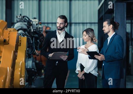 Der Eigentümer der Roboterfabrik erklärt und bespricht die Funktionalität und Leistung der Robotersysteme mit dem Kunden. Beantwortung von Fragen zum Kundendienst. Pric Stockfoto