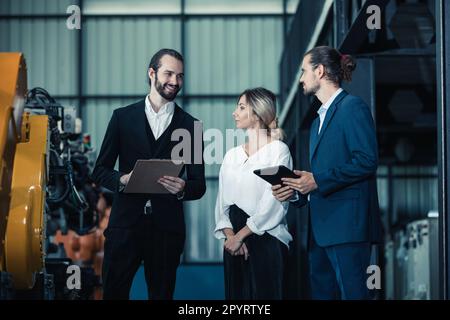 Der Eigentümer der Roboterfabrik erklärt und bespricht die Funktionalität und Leistung der Robotersysteme mit dem Kunden. Beantwortung von Fragen zum Kundendienst. Pric Stockfoto