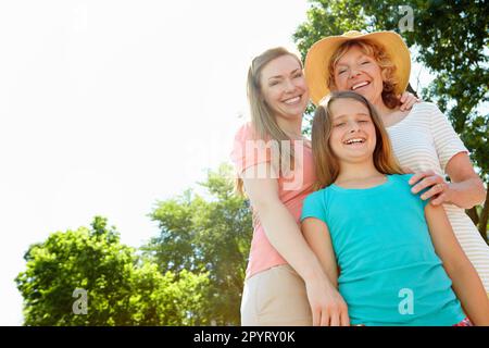 Genießen Sie gemeinsam die Sommerstrahlen - 3 Generationen. Ein süßes junges Mädchen, das den Tag in der Sommersonne mit ihrer Großmutter und ihrer Mutter verbringt. Stockfoto