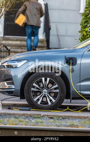 Göteborg, Schweden - Oktober 03 2022: Ein blauer Hybrid-Volvo, der vor einem Haus auflädt Stockfoto