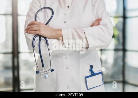 Zuversichtlich Ärztin posiert in ihrem Büro und lächelnd in die Kamera, Gesundheitsvorsorge und Prävention-Konzept Stockfoto
