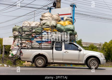 Ein Pick-up-Auto, beladen mit vielen Säcken, fährt auf einer Straße nach Thailand Stockfoto