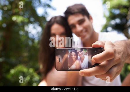 Stellen Sie sich eine perfekte Romanze vor. Ein junges Paar, das ein Selbstporträt macht, während es einen Tag im Freien genießt. Stockfoto