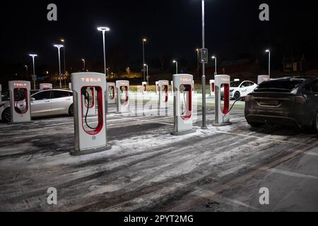 Göteborg, Schweden - dezember 09 2022: Autos laden nachts an Tesla Supercharger auf Stockfoto