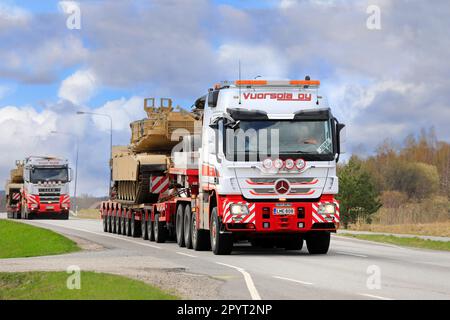 Mercedes-Benz-Lkw transportiert amerikanischen M1 Abrams Militärpanzer auf Auflieger. Konvoi mit 3 außergewöhnlichen Ladungstransporten. Salo, Finnland. 28. April 2023. Stockfoto