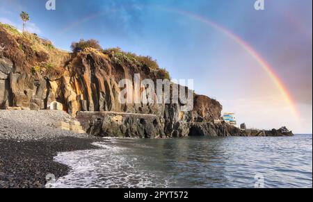 Regenbogen über dem schwarzen Strand von Formosa in Madeira, Portugal Stockfoto