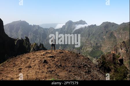 Madeira, Portugal. Ein Mann fotografiert auf einem Wanderweg zwischen Pico do Arieiro und Pico do Ruivo bei Sonnenuntergang über den Wolken Stockfoto