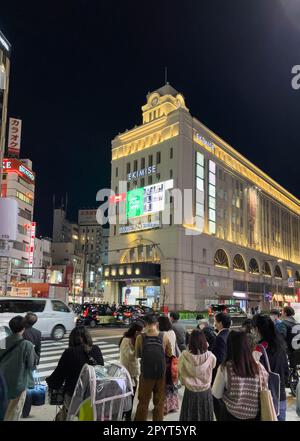 Ein Abendfoto von der Außenseite des Bahnhofs Asakusa, von dem die Tobu-Linie fährt, mit einer großen Gruppe von Touristen, die darauf warten, die Straße zu überqueren. Stockfoto