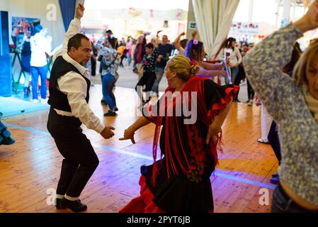 Menschen in traditionellen andalusischen Kleidern werden bei den Festen für die „Feria de Abril“ im Forum Park flamencowährend tanzen gesehen. Der Jahrmarkt, wissen Sie Stockfoto