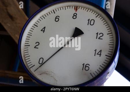 Altes Rundmanometer mit Skala und Pfeilen im Nahbereich. Stockfoto