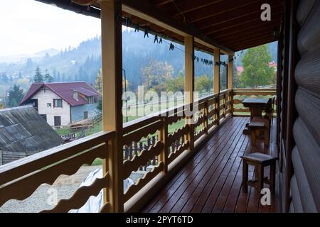 Schöne moderne Terrassenlounge, große Holzterrasse in einem Holzhaus mit Wald. Natur- und Urlaubskonzept. Stockfoto